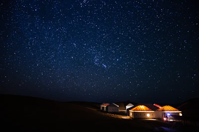 Night view of Yatrinest’s exterior lit softly under the stars.