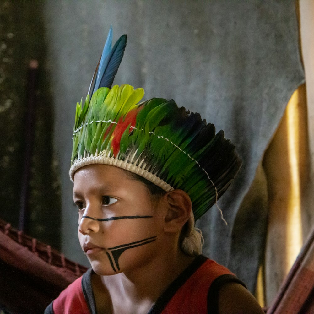 woman in red and white shirt wearing green and yellow headdress