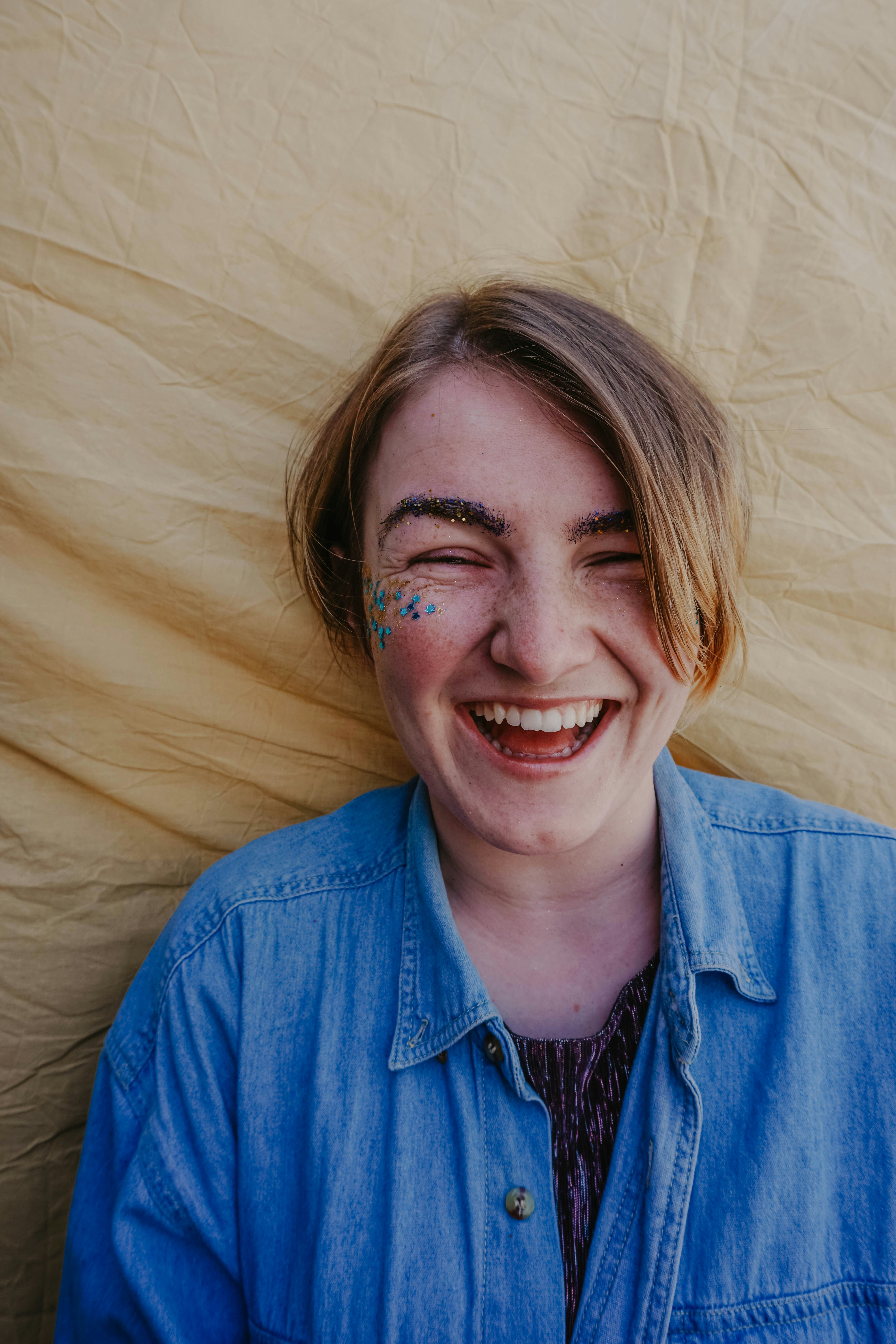 woman in blue button-up shirt lying on fabric