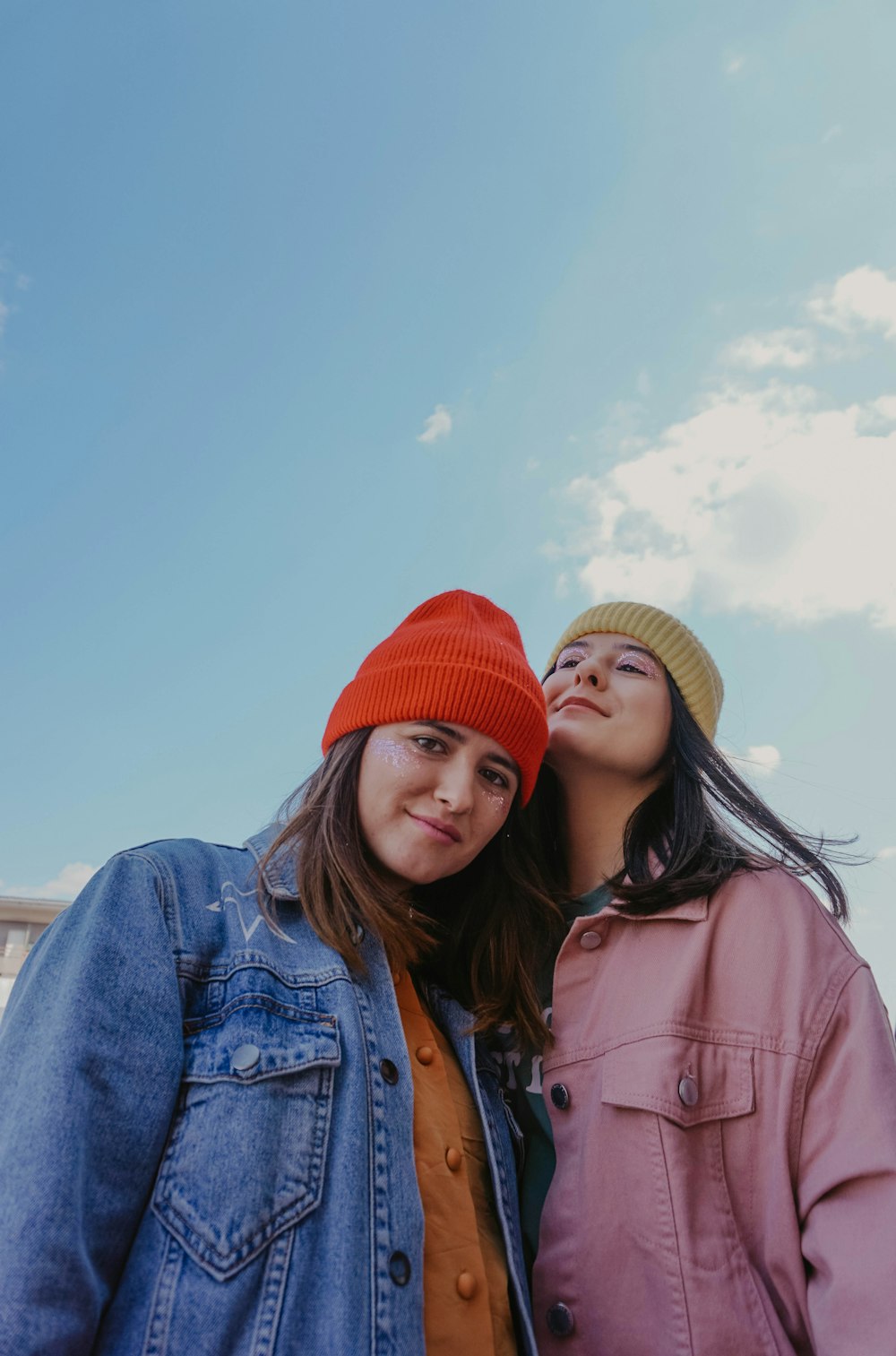 woman in blue denim jacket beside woman in pink jacket