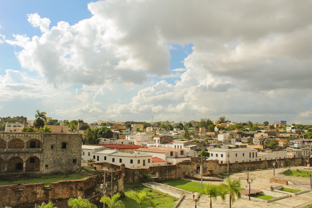 Edificios de hormigón blanco y marrón bajo nubes blancas durante el día