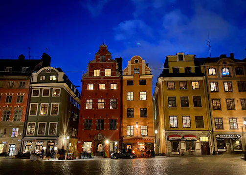 A charming European cityscape featuring cobblestone streets and historic architecture under a deep navy sky.