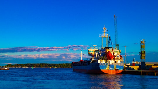 blue and red ship on sea under blue sky during daytime in Poole Harbour United Kingdom