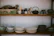 A cozy kitchen shelf displaying colorful ceramic bowls from širdies molis.