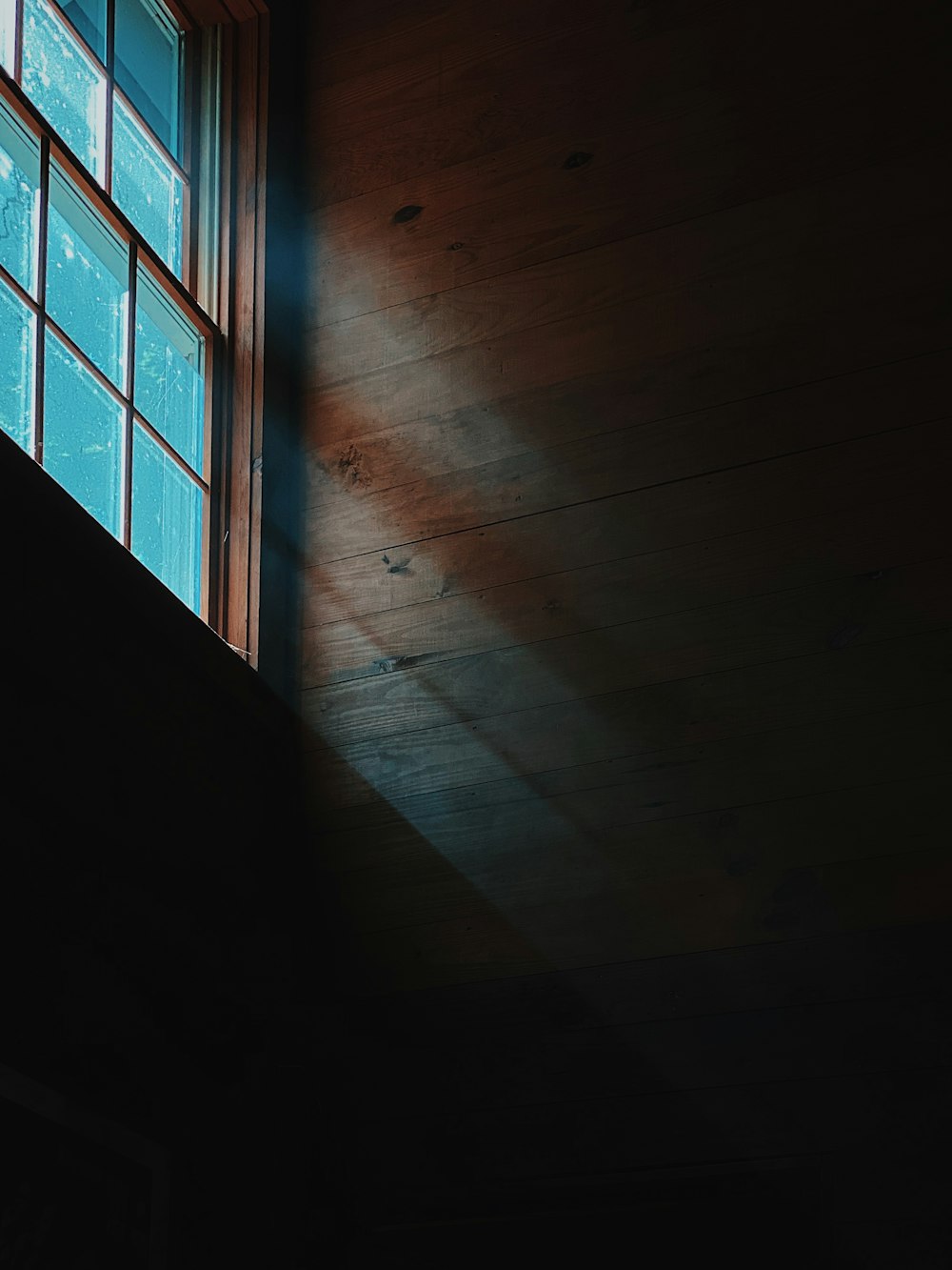 brown wooden floor near glass window