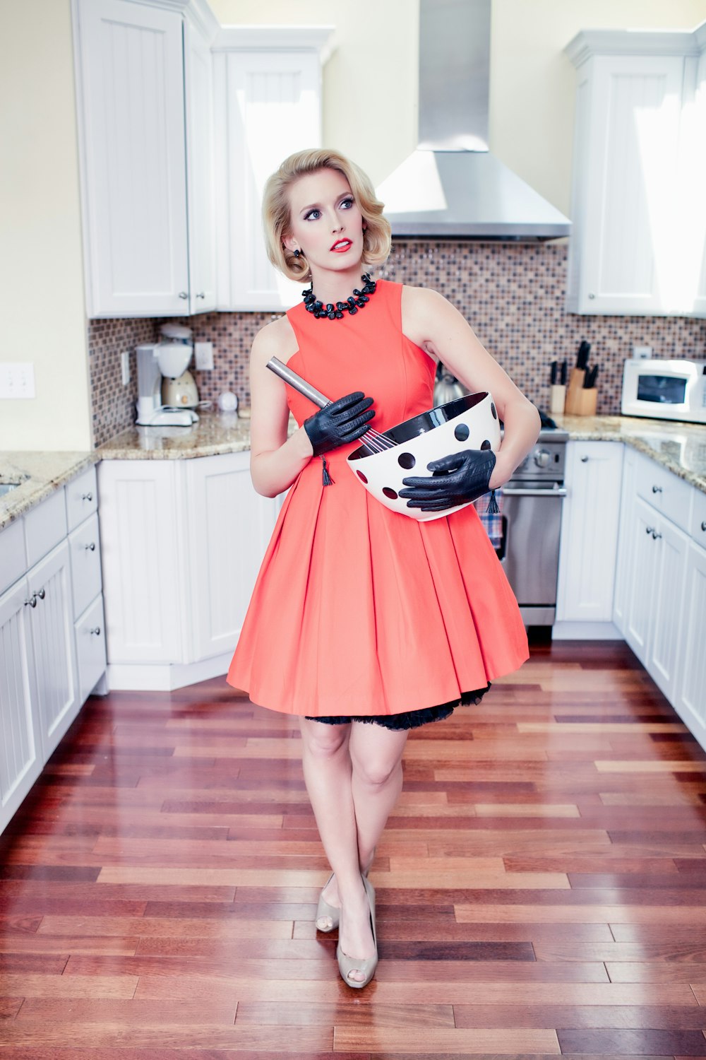 girl in red dress holding black and white electric guitar