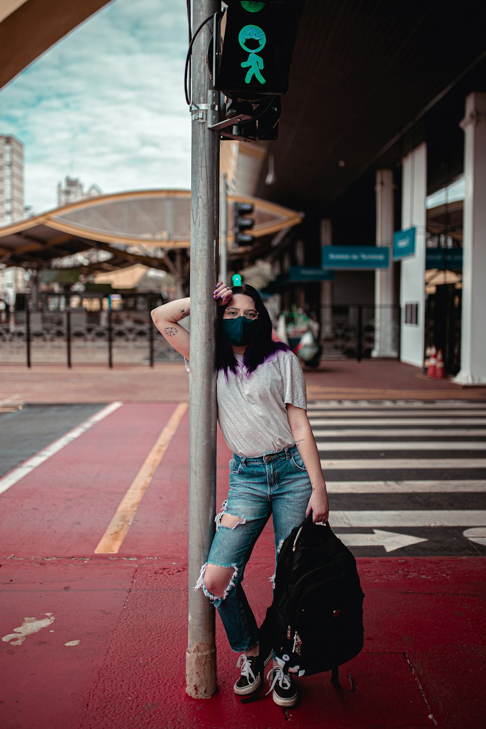 woman in gray shirt and black pants sitting on gray wooden bench