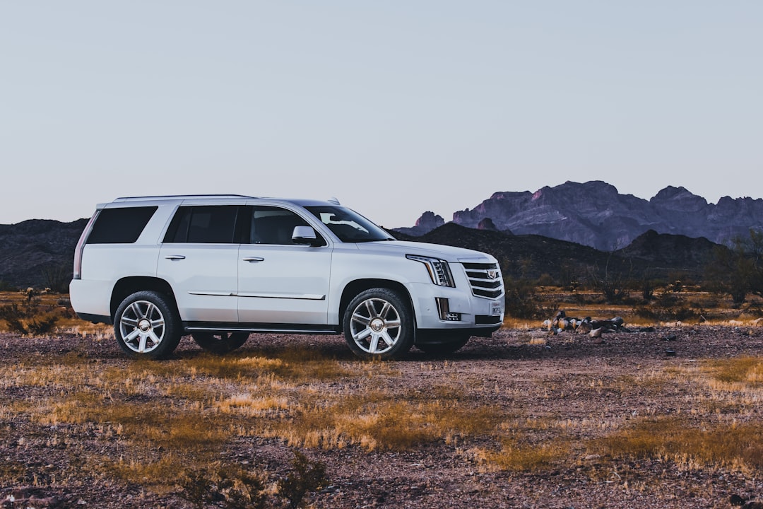 Pearl white Cadillac Escalade at Campsite in the Arizona Desert with mountains in the background.