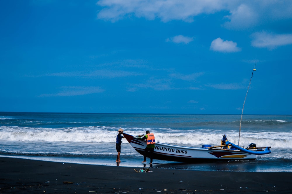 man in green shirt and black shorts standing on beach shore during daytime