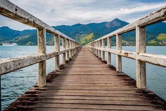 brown wooden dock on body of water during daytime in São Sebastião Brasil