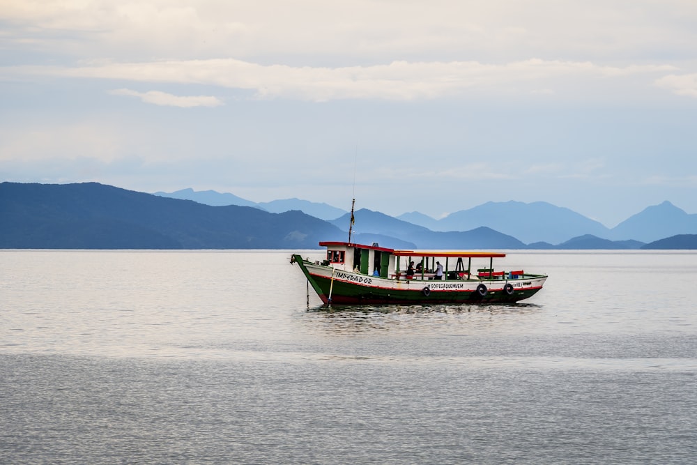 rotes und schwarzes Boot tagsüber auf See