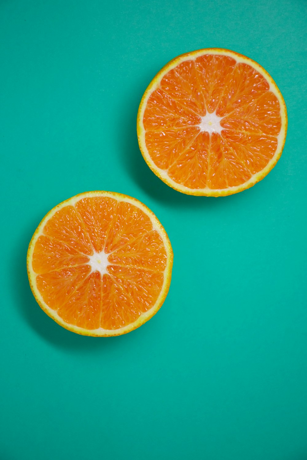 in Scheiben geschnittene Orangenfrüchte auf blauer Oberfläche