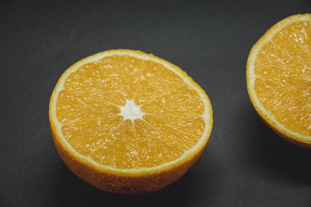 fruta laranja fatiada no tecido preto