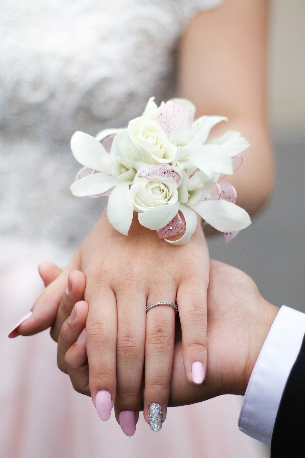 person holding white flower with green leaves