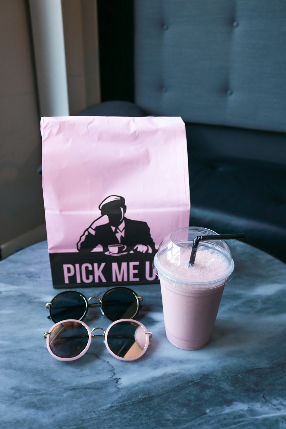 black framed sunglasses beside white disposable cup