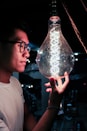 boy in white crew neck shirt holding clear glass ball