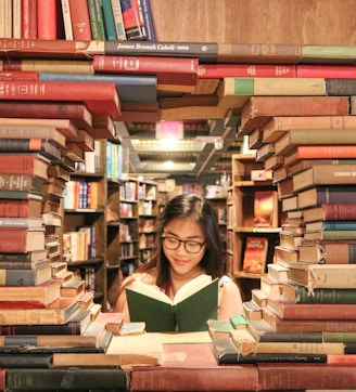 woman in green shirt sitting on books