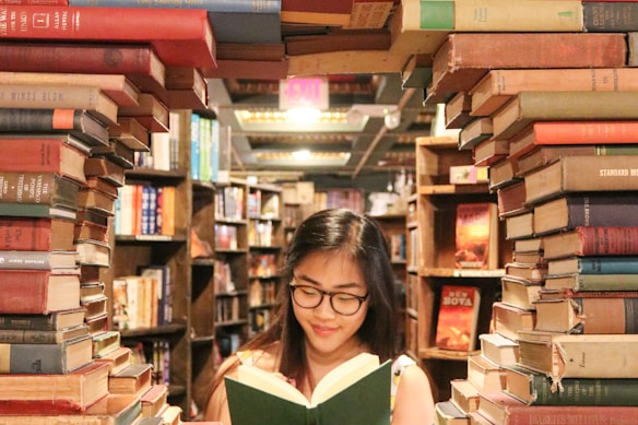 woman in green shirt sitting on books