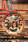 woman in green shirt sitting on books