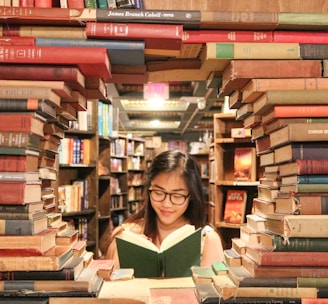 woman in green shirt sitting on books