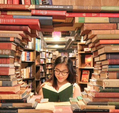 woman in green shirt sitting on books