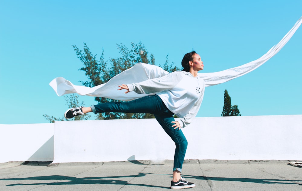 a woman in a white shirt is doing a dance move