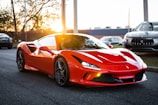 A sleek red sports car gleaming under golden hour sunlight on an open road.