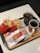 A fast food meal consisting of two packs of French fries, a wrapped burger, a glass of soda with ice, and a cup of black coffee on a tray with branded packaging.
