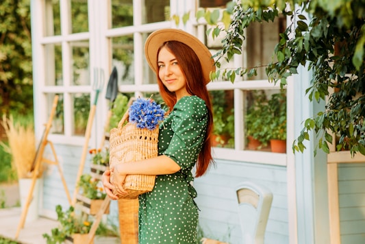 woman in green and white polka dot dress holding brown woven basket