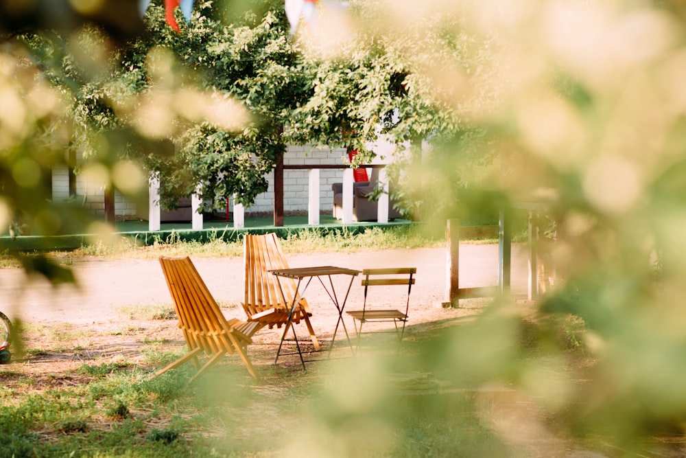 brown wooden chairs and table near white and red house