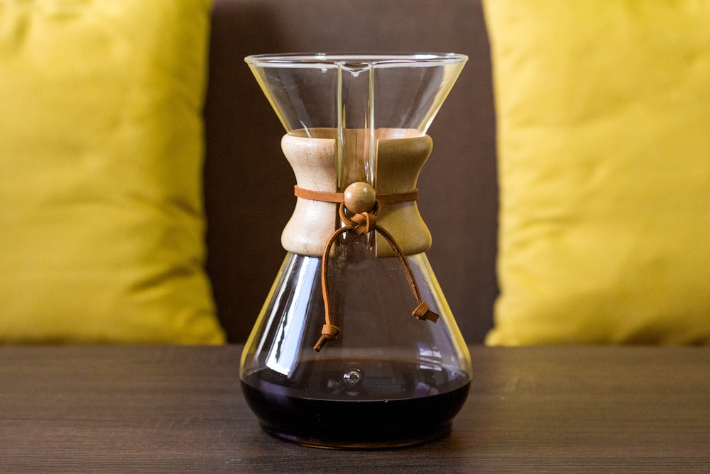 clear glass bottle on brown wooden table