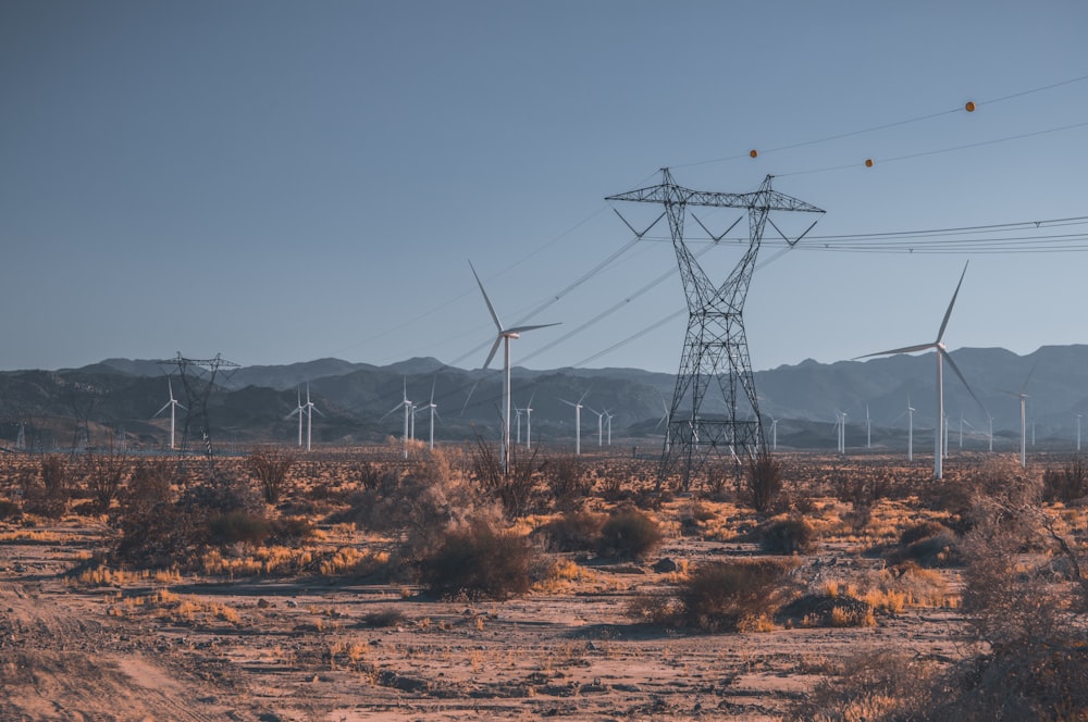 black electric towers on brown field during daytime