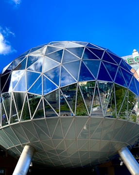 A modern dome structure with glass panels reflecting the sky.