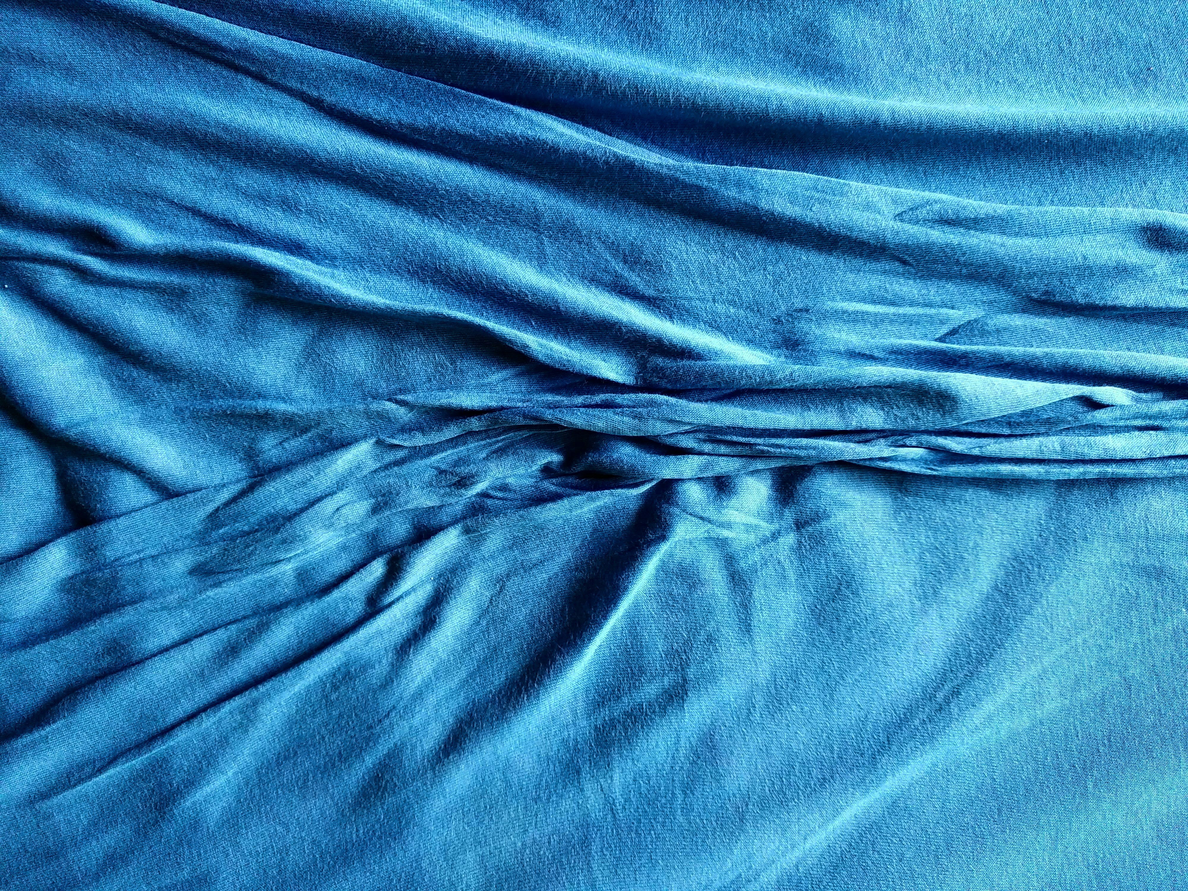 Indigo blue chambray shirting fabric with soft denim-like appearance in natural daylight setting