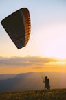 silhouette of person on parachute during sunset