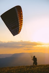 silhouette of person on parachute during sunset