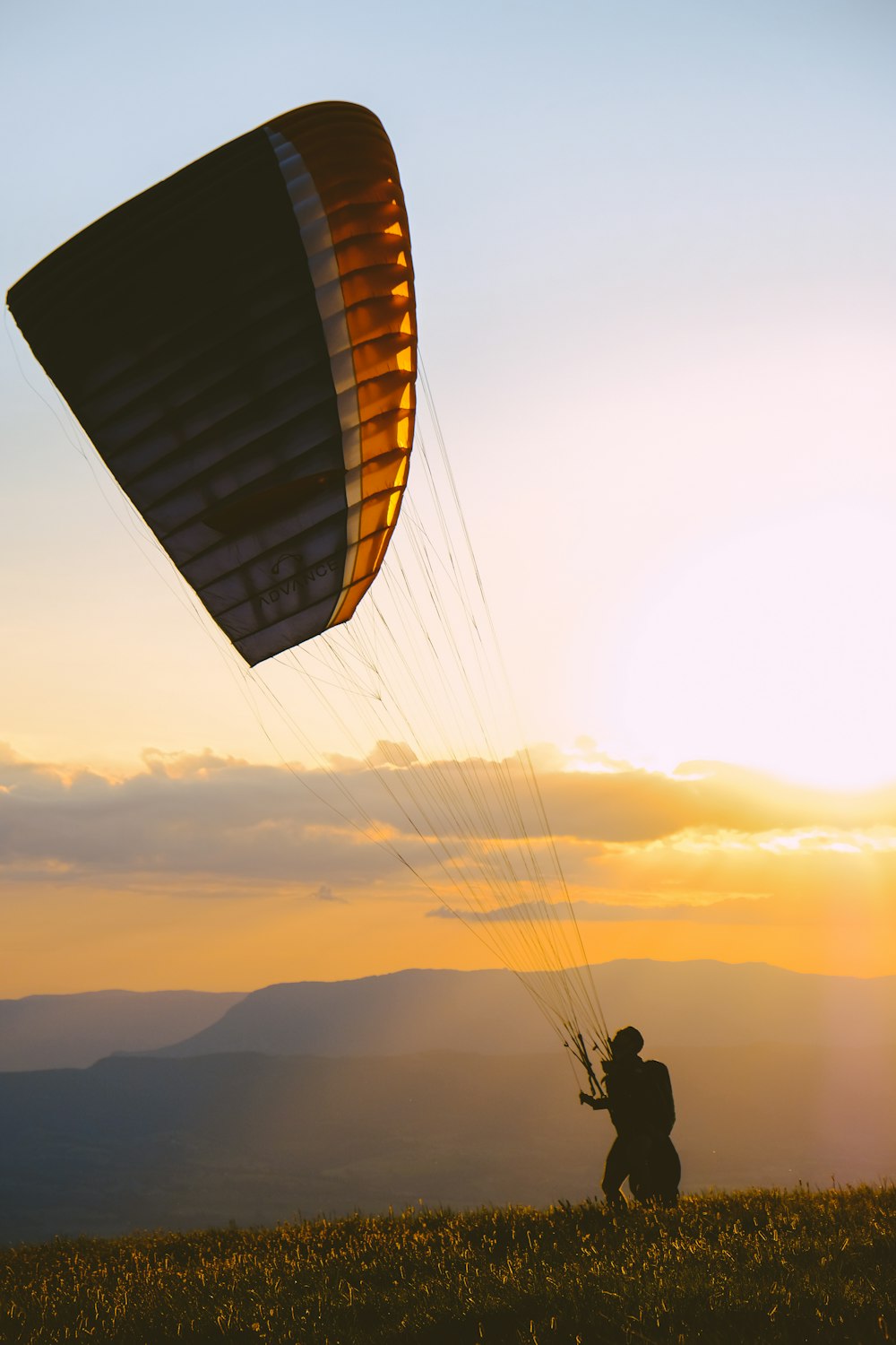 silhouette of person on parachute during sunset