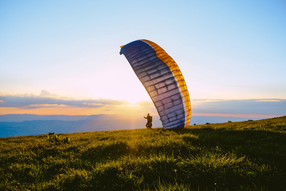 Silueta de la persona que monta el paracaídas durante la puesta del sol