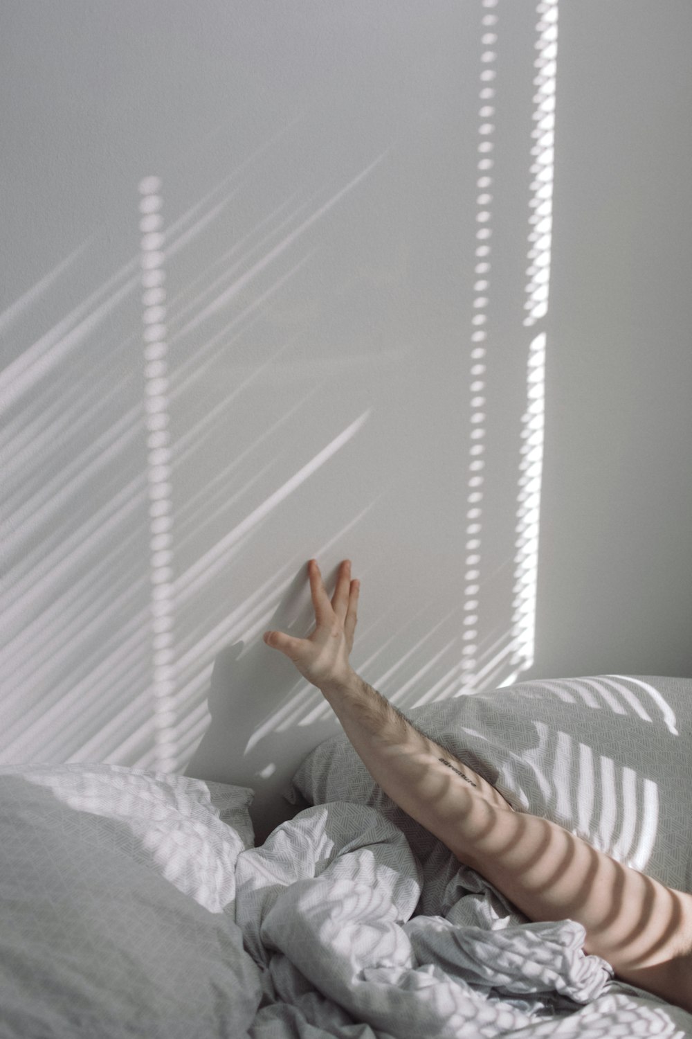 person lying on bed near window