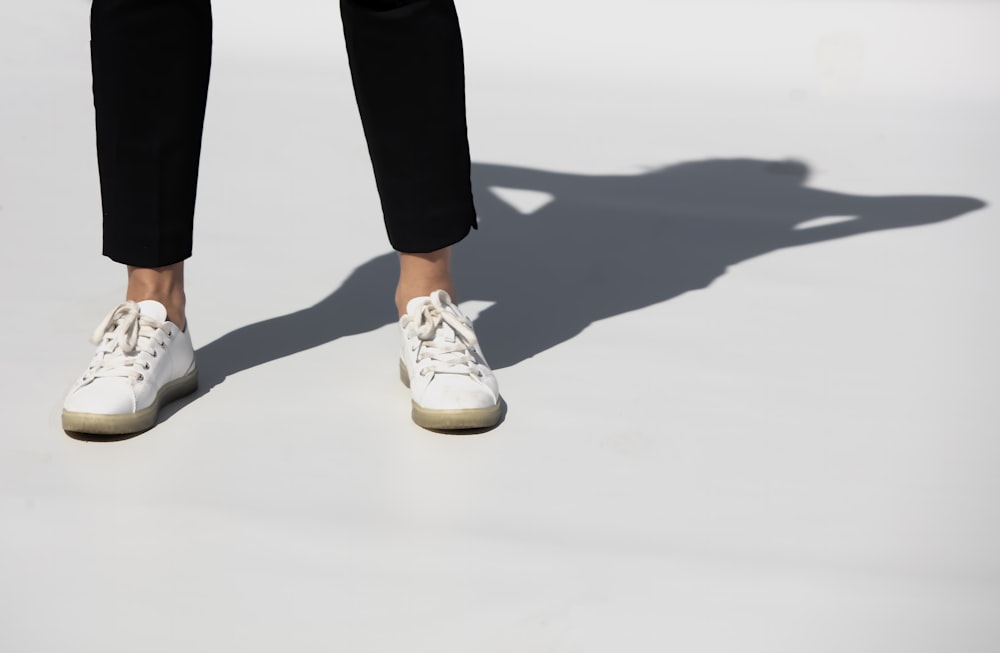 person in black pants and white and brown nike sneakers