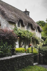 A charming stone cottage with blooming flowers at the entrance.