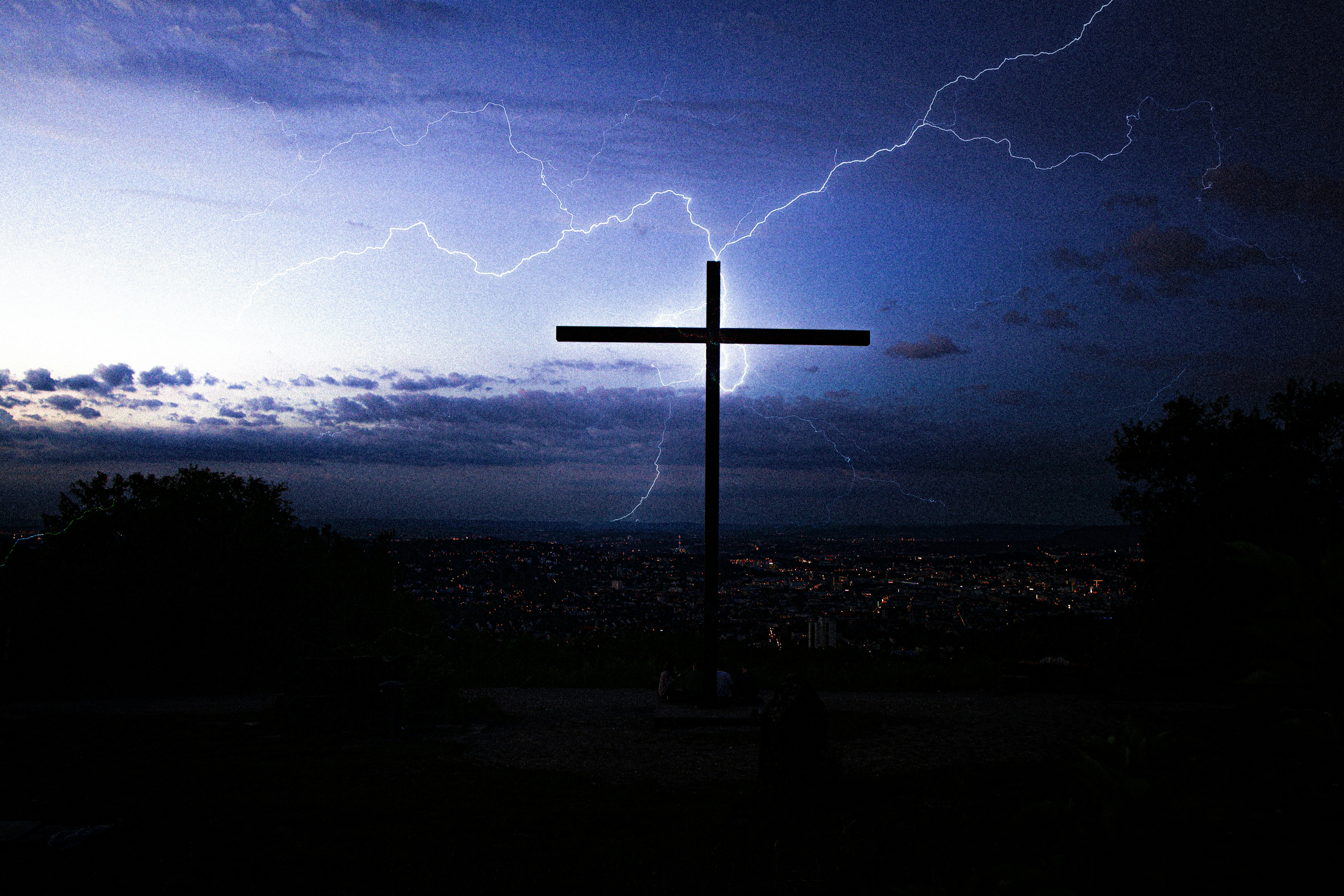 silhouette of cross under cloudy sky during night time