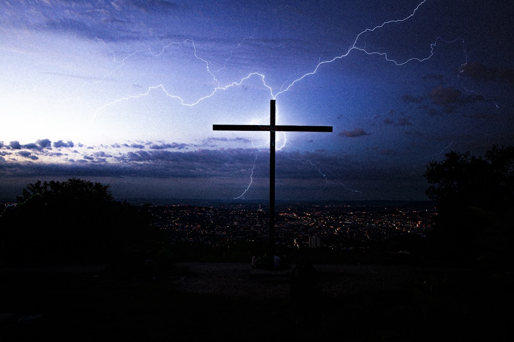 夜の曇り空の下での十字架のシルエット