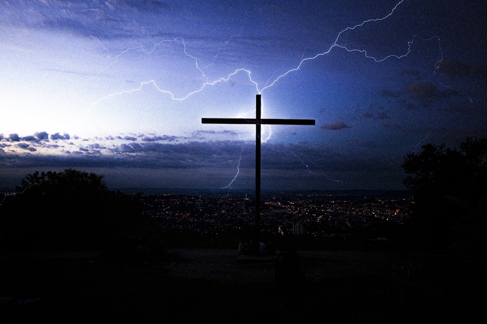 silhouette of cross under cloudy sky during night time