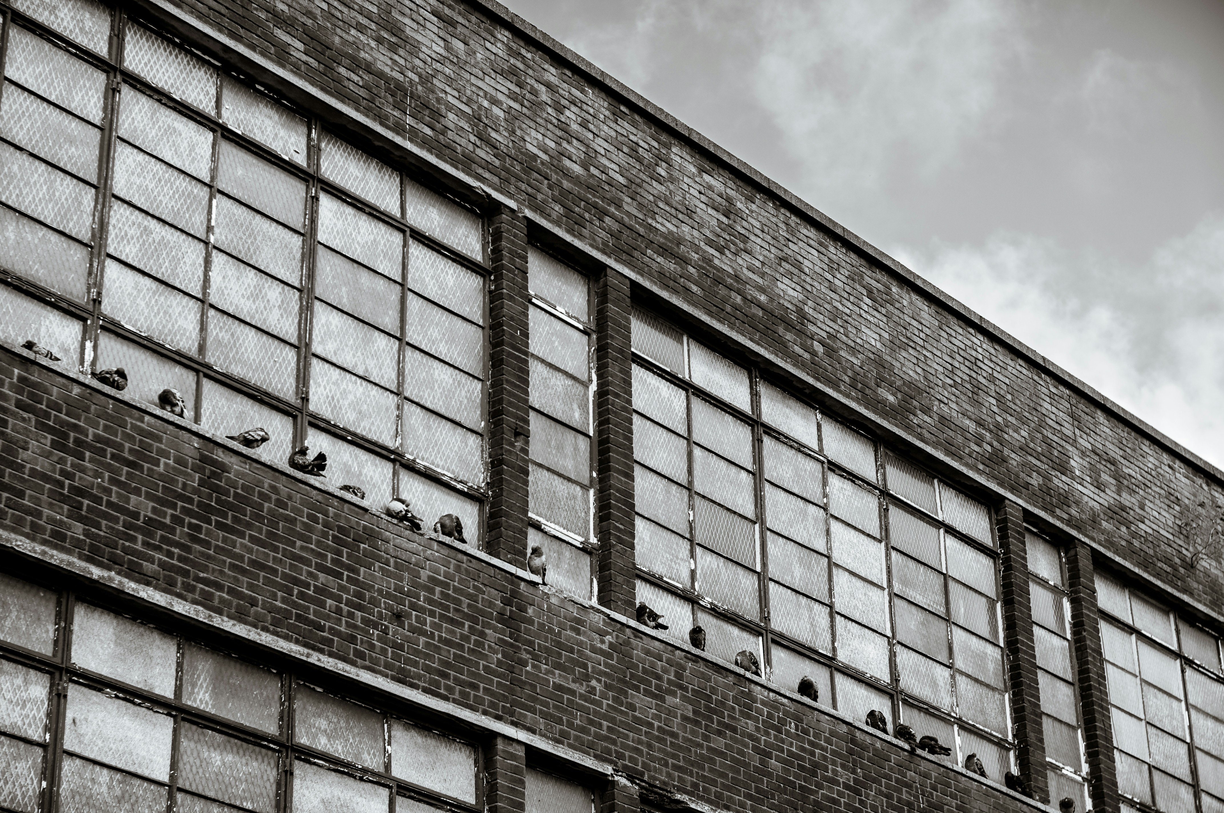 brown brick building under white clouds during daytime