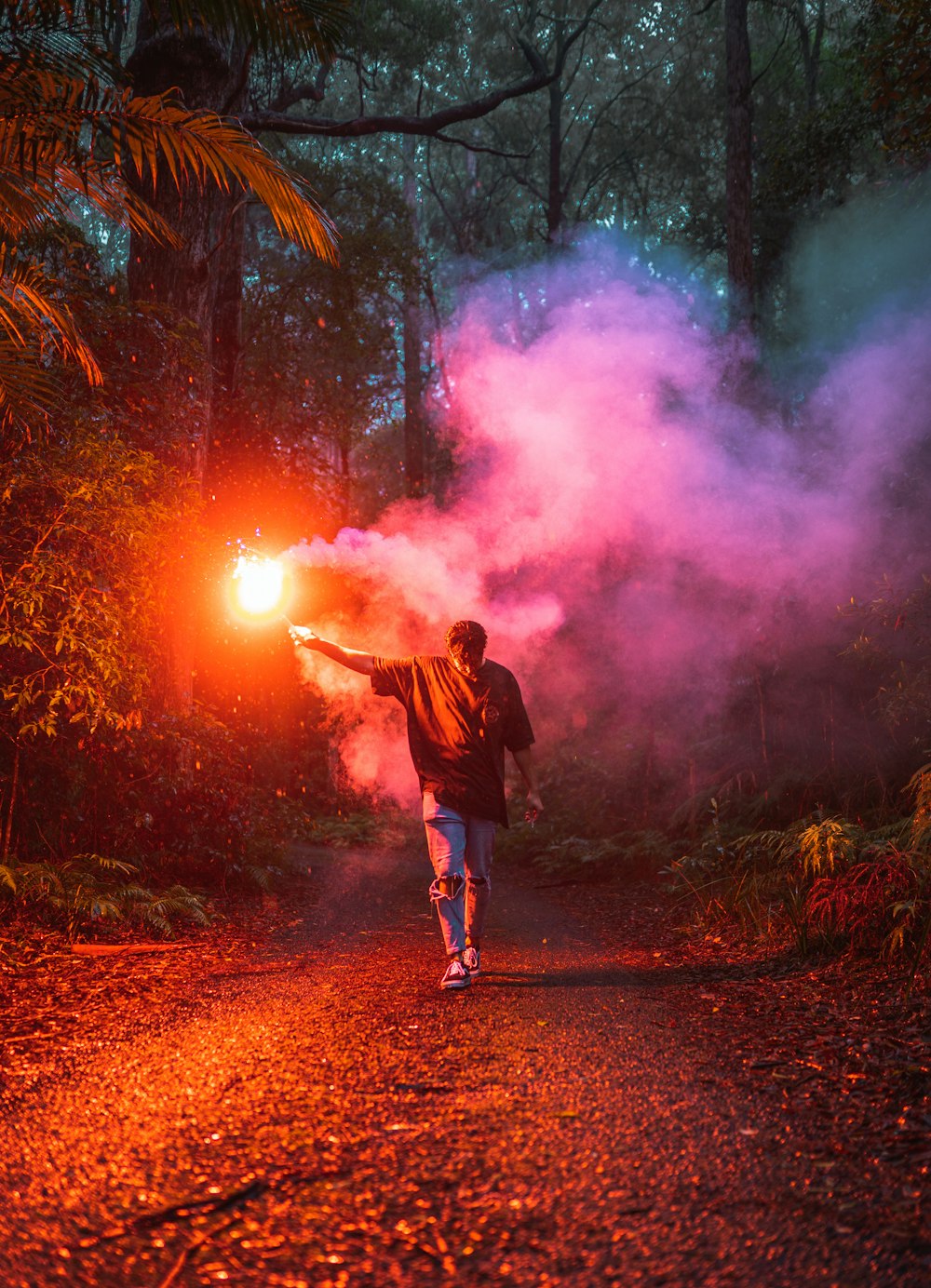 man in black jacket standing on brown dirt road during nighttime