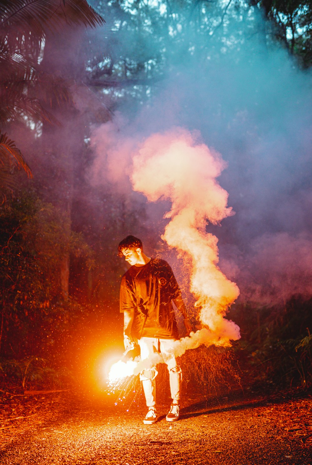 man in black jacket standing in front of fire