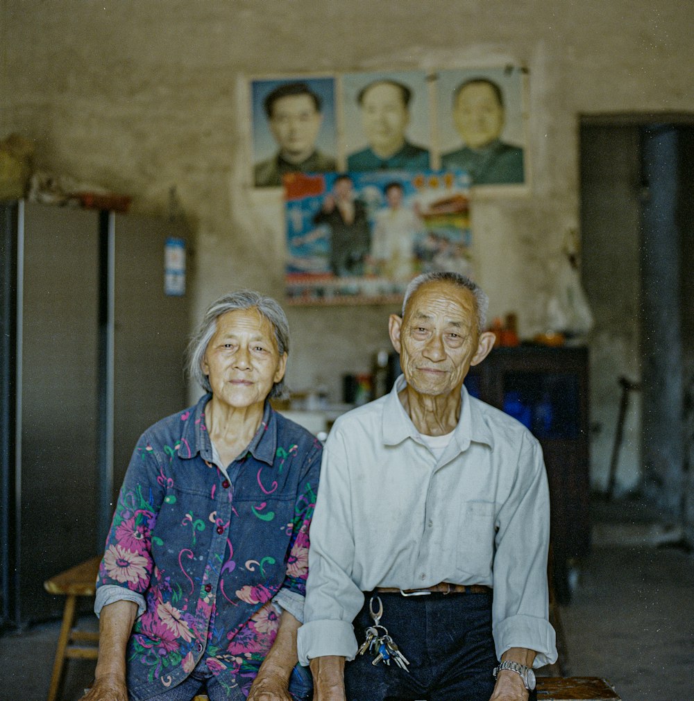 man in white dress shirt sitting beside woman in purple and pink floral dress