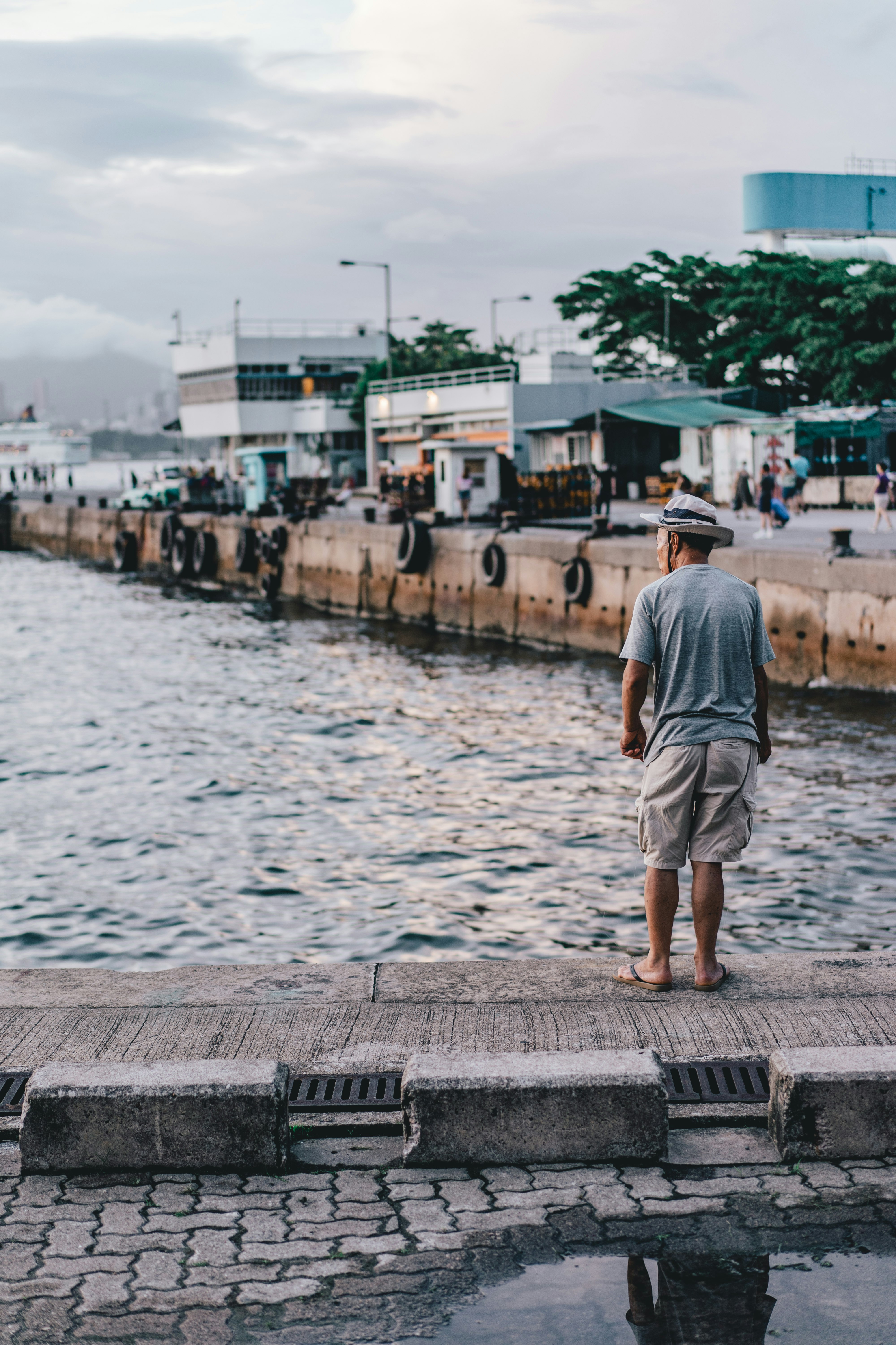 man in grey shirt walking on dock during daytime