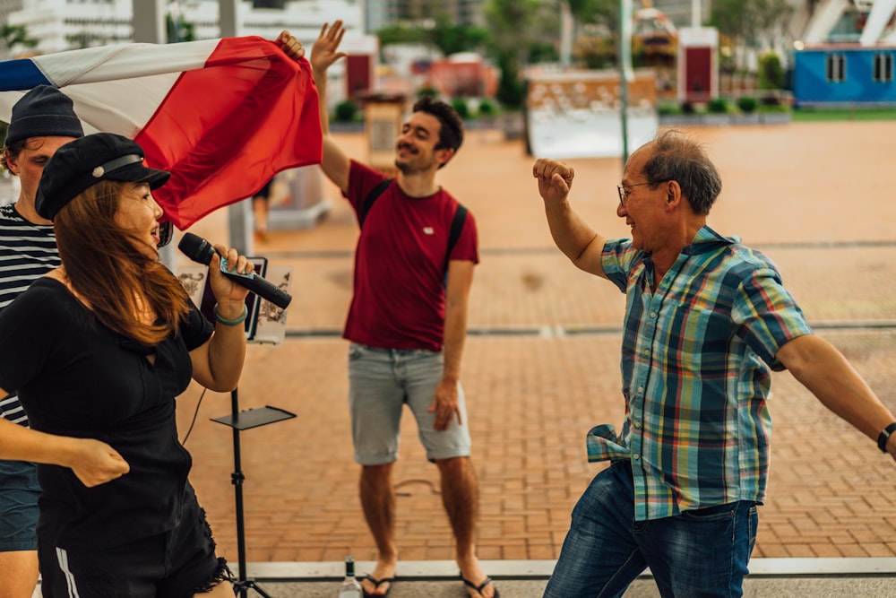 man in red crew neck t-shirt and blue denim shorts standing beside man in blue